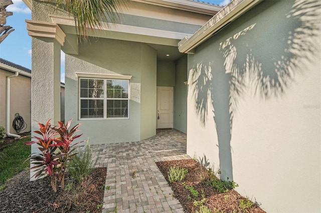 view of exterior entry with a patio