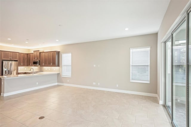 unfurnished living room with light tile patterned floors and sink