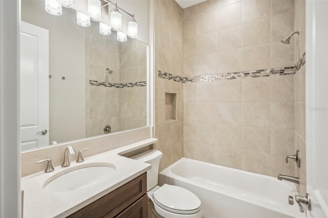 full bathroom with vanity, tiled shower / bath combo, and toilet