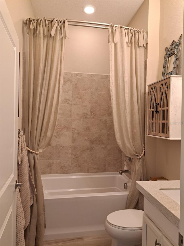 full bathroom featuring vanity, shower / tub combo with curtain, and toilet