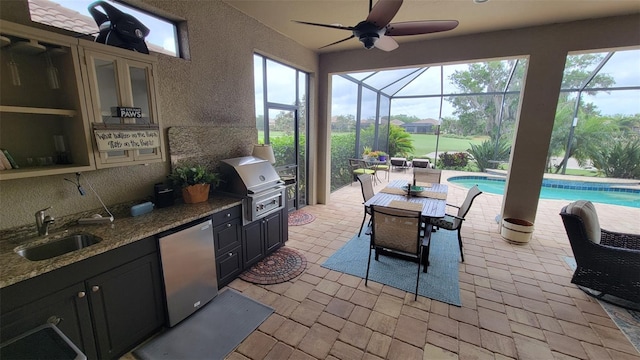 view of patio featuring area for grilling, a grill, sink, glass enclosure, and ceiling fan