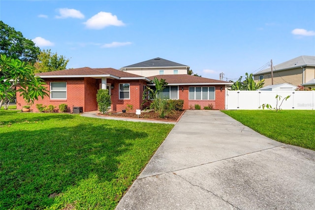 view of front facade featuring a front lawn, fence, and brick siding