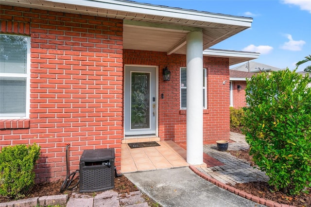 doorway to property with brick siding