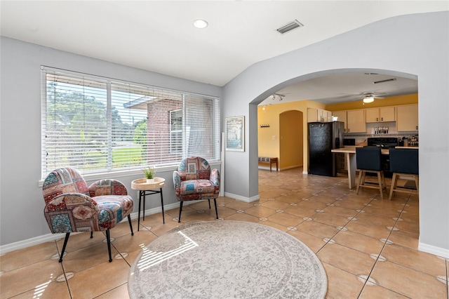 living area with light tile patterned floors, ceiling fan, and lofted ceiling