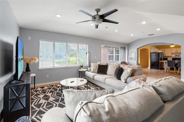 living area featuring arched walkways, baseboards, lofted ceiling, ceiling fan, and recessed lighting