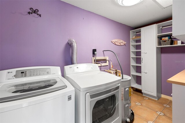 clothes washing area with light tile patterned floors, baseboards, cabinet space, and independent washer and dryer