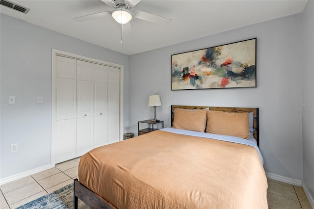 tiled bedroom with ceiling fan and a closet