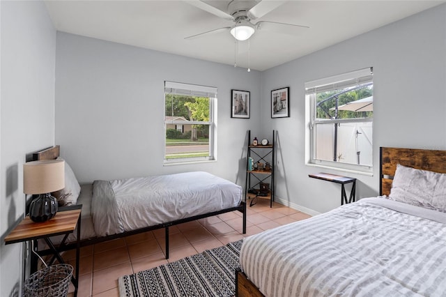 tiled bedroom featuring ceiling fan and multiple windows