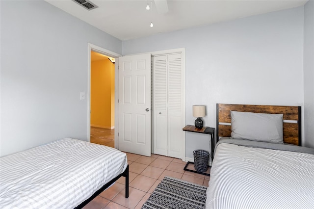 tiled bedroom featuring ceiling fan and a closet