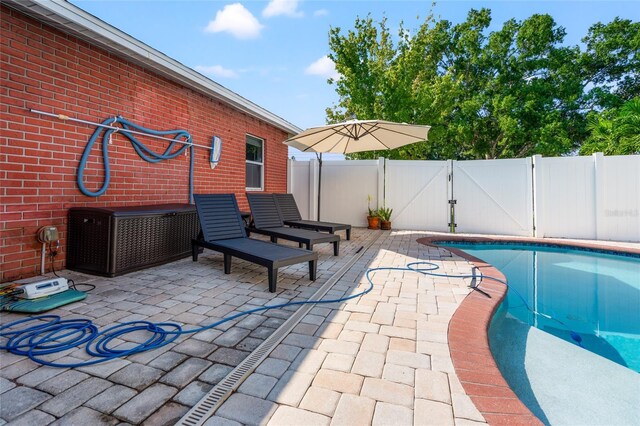 view of swimming pool with a gate, fence, a fenced in pool, and a patio