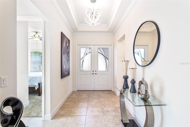 entrance foyer featuring light tile patterned floors, crown molding, a raised ceiling, and ceiling fan with notable chandelier