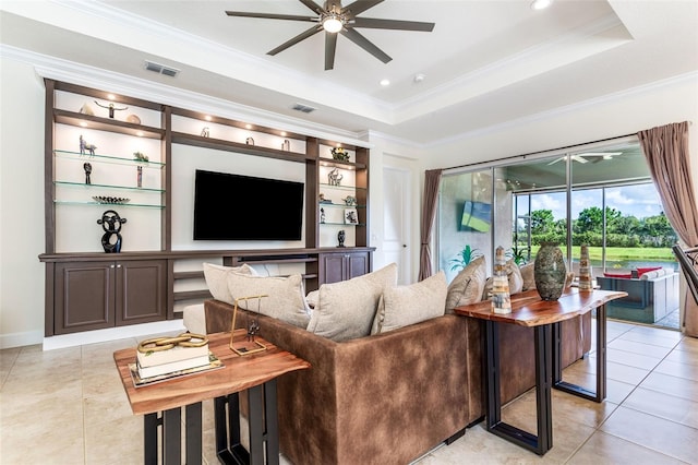 living room with crown molding, ceiling fan, light tile patterned floors, and a tray ceiling