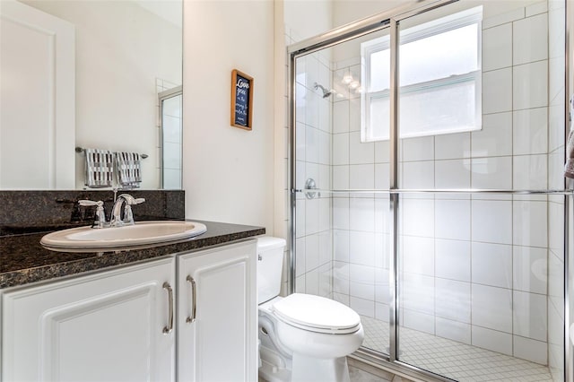 bathroom with walk in shower, toilet, and vanity