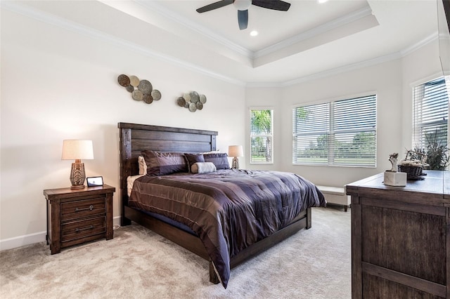 carpeted bedroom featuring ceiling fan, ornamental molding, and a tray ceiling