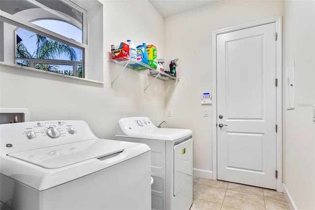 washroom featuring washer and clothes dryer and light tile patterned floors