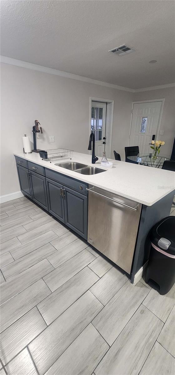 kitchen featuring stainless steel dishwasher, light hardwood / wood-style floors, and sink