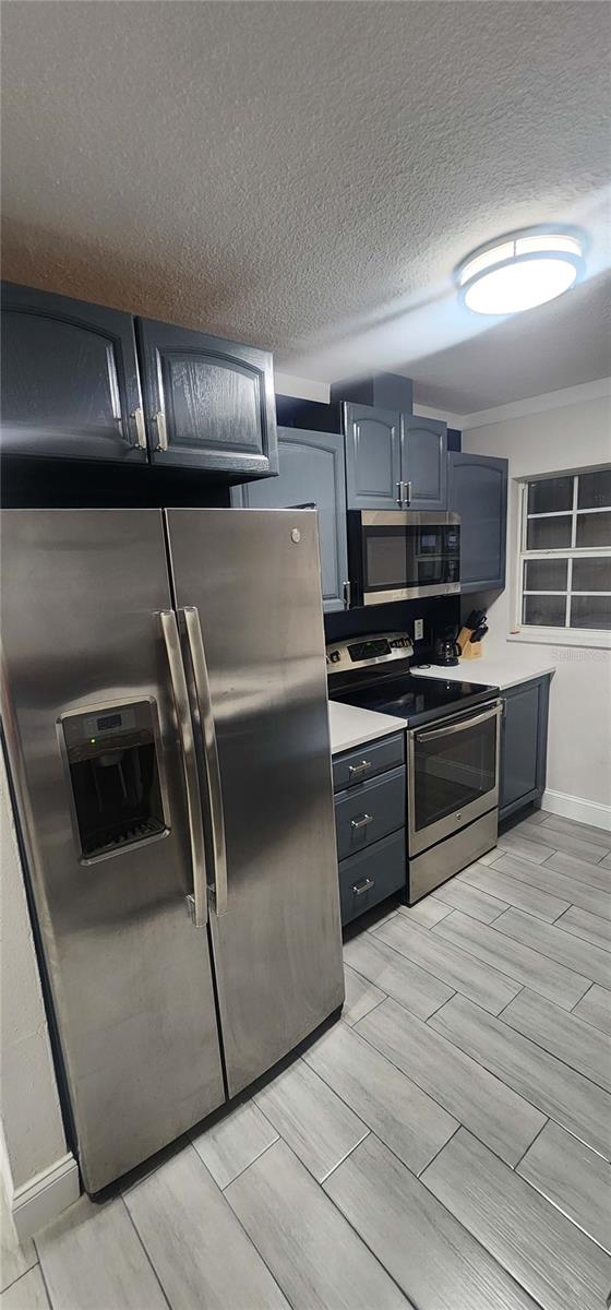 kitchen featuring appliances with stainless steel finishes and a textured ceiling