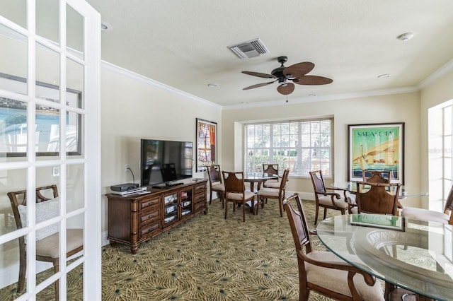 carpeted living room featuring ceiling fan and ornamental molding