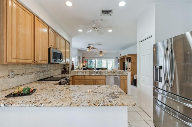 kitchen with backsplash, light tile patterned floors, appliances with stainless steel finishes, kitchen peninsula, and ceiling fan