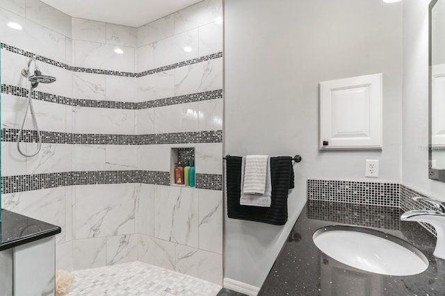 bathroom featuring tiled shower and vanity