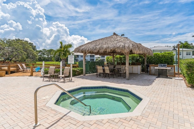 view of pool featuring a patio area, grilling area, a hot tub, and a gazebo