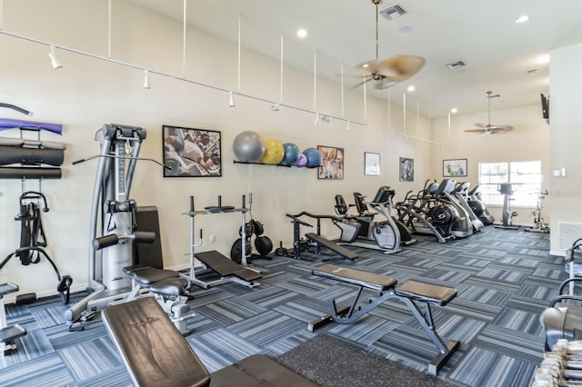 workout area with ceiling fan, dark colored carpet, and a high ceiling