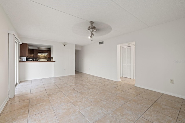 unfurnished room featuring ceiling fan, a textured ceiling, and light tile patterned flooring