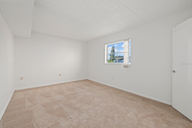 unfurnished room featuring a textured ceiling and light carpet