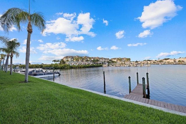 dock area with a lawn and a water view