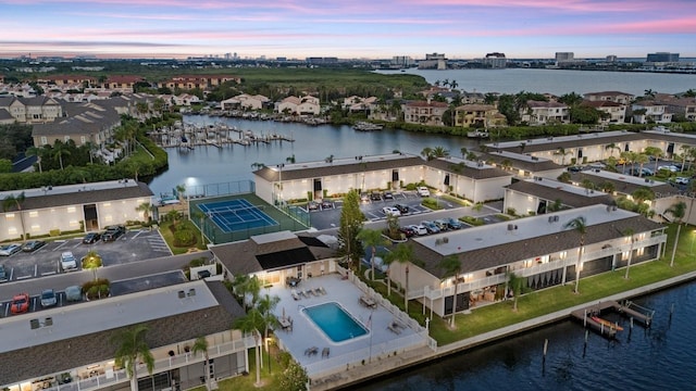 aerial view at dusk featuring a water view