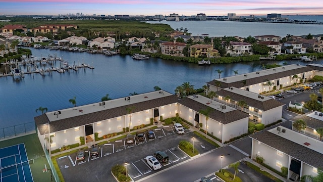 aerial view at dusk featuring a water view