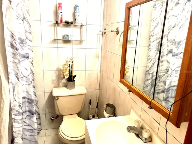 bathroom featuring tile walls, toilet, sink, and a shower with shower curtain