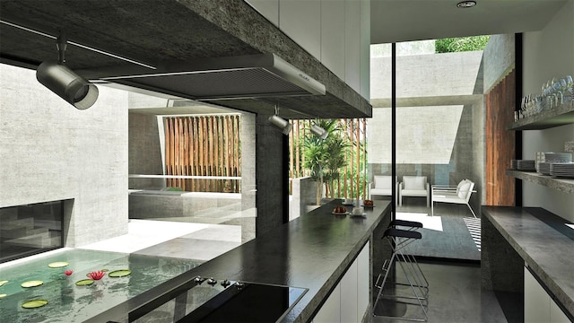 kitchen featuring stovetop, plenty of natural light, and white cabinets