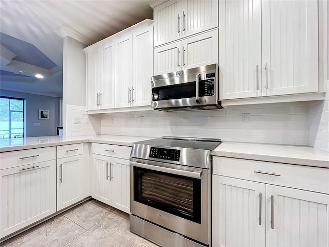 kitchen with backsplash, stainless steel appliances, white cabinetry, and light tile patterned floors