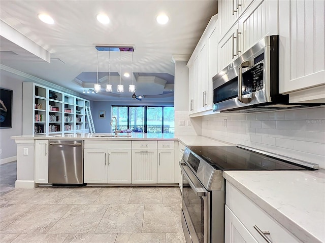 kitchen with appliances with stainless steel finishes, light tile patterned floors, kitchen peninsula, and sink