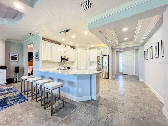 kitchen featuring white cabinets, appliances with stainless steel finishes, decorative light fixtures, a peninsula, and light countertops