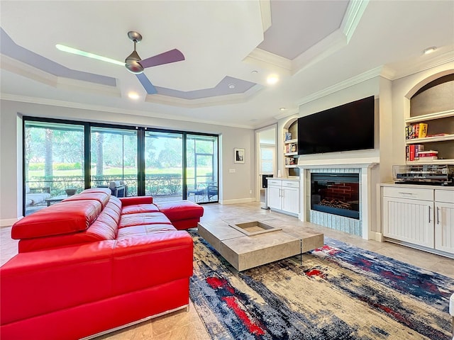 tiled living room featuring ceiling fan, plenty of natural light, ornamental molding, and built in features