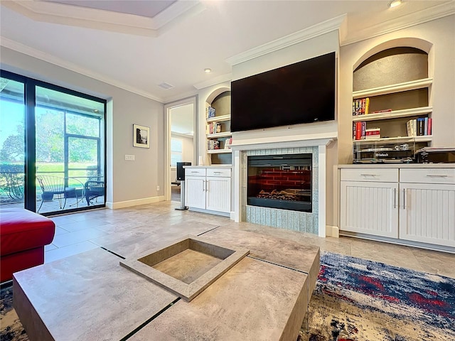 living area with visible vents, baseboards, a tiled fireplace, crown molding, and built in shelves