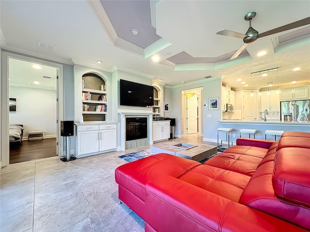 living room featuring ornamental molding, baseboards, built in features, and a ceiling fan