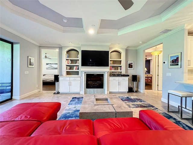 living area featuring built in features, visible vents, ornamental molding, and a tiled fireplace