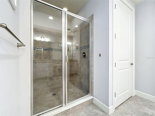 bathroom with a stall shower and baseboards