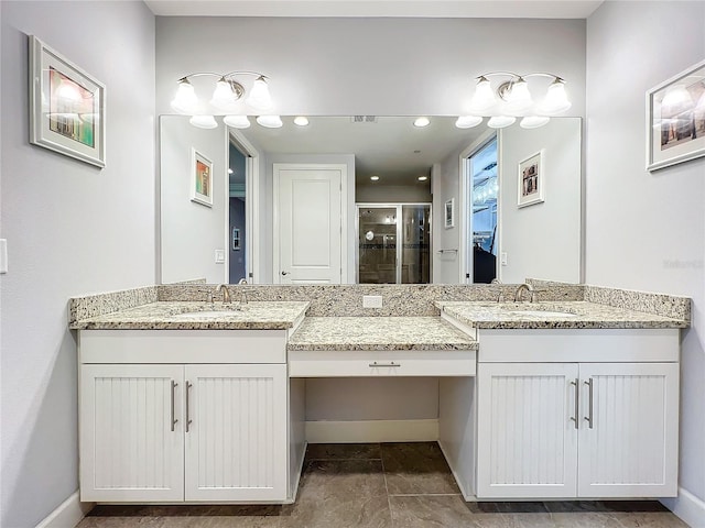 bathroom featuring tile patterned floors, dual vanity, and a shower with shower door