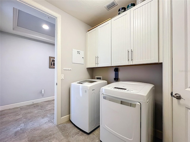 laundry room with cabinet space, baseboards, visible vents, and washer and dryer