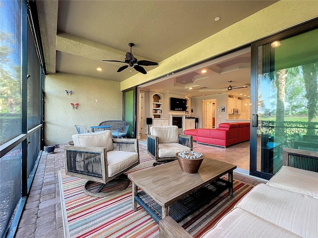 sunroom / solarium featuring ceiling fan