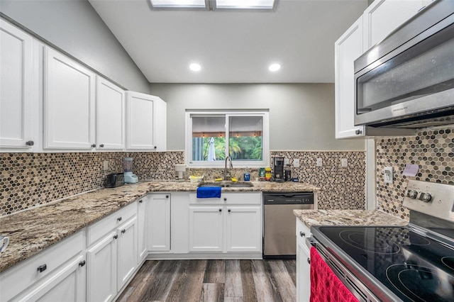 kitchen featuring sink, dark hardwood / wood-style flooring, appliances with stainless steel finishes, light stone countertops, and tasteful backsplash