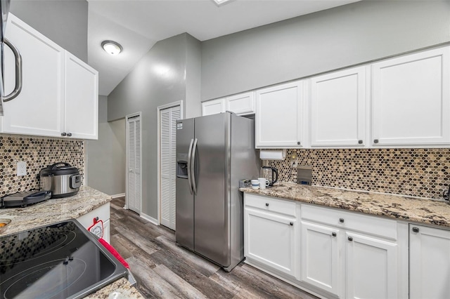 kitchen with backsplash, light stone counters, dark hardwood / wood-style floors, stainless steel fridge with ice dispenser, and lofted ceiling