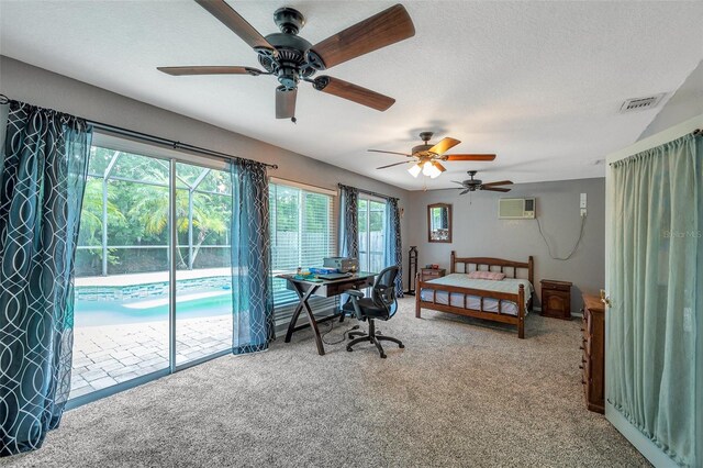 carpeted bedroom with ceiling fan, access to outside, a textured ceiling, and a wall unit AC