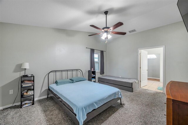 bedroom featuring ensuite bath, ceiling fan, and light carpet