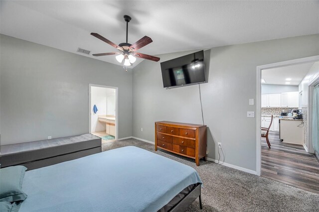 bedroom with ceiling fan, lofted ceiling, connected bathroom, and carpet flooring