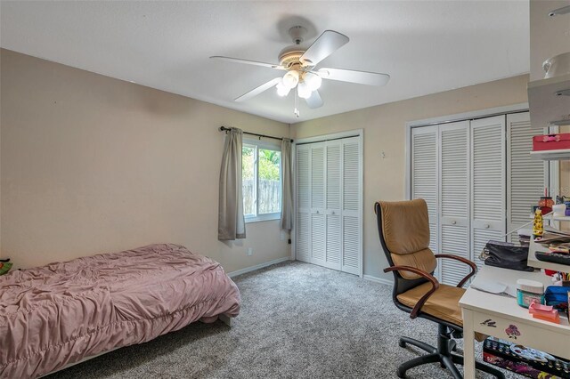 bedroom with carpet flooring, ceiling fan, and multiple closets